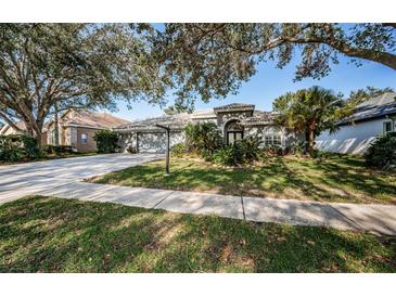 Beautiful two-story home with a three-car garage and manicured lawn at 5256 Kernwood Ct, Palm Harbor, FL 34685