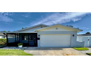 Charming single-story home with a white exterior, attached garage, and a well-maintained lawn at 4501 Helena Ne St, St Petersburg, FL 33703