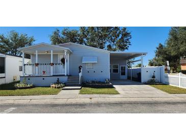 Well-maintained manufactured home with covered porch, carport, and landscaped yard at 8346 Fantasia Park Way, Riverview, FL 33578