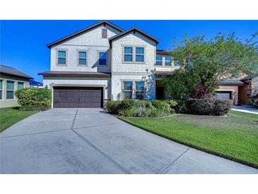 Two-story house with a large driveway and landscaped lawn at 11807 Cross Vine Dr, Riverview, FL 33579