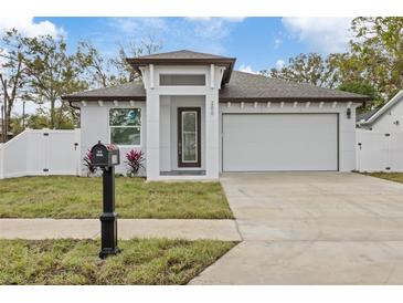 Modern one-story house with a white exterior, two-car garage, and landscaped front yard at 200 W Kirby St, Tampa, FL 33604