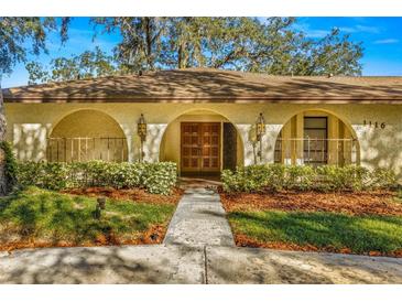 Spanish style home with a lush, manicured lawn and walkway at 1116 N Riverhills Dr, Temple Terrace, FL 33617