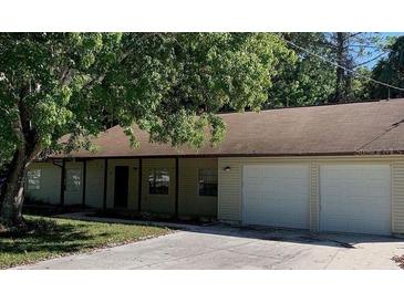 Ranch-style home with two-car garage and mature landscaping at 3384 Fremont Ln, Spring Hill, FL 34607