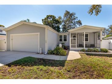 Gray house with attached garage and screened porch at 703 Old Charleston Way, Largo, FL 33770