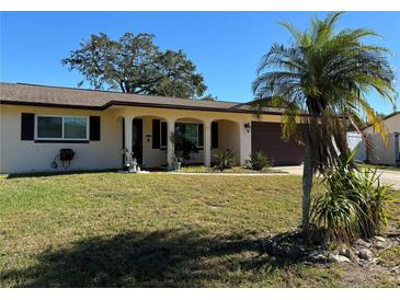 Single-story home with a brown roof, attached garage, and well-maintained lawn at 10373 137Th Ln, Largo, FL 33774