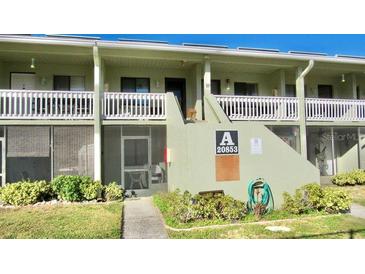 Two-story building with balconies and a landscaped yard at 20853 Haulover Cv # A8, Lutz, FL 33558