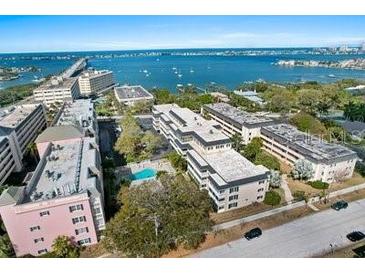 Beautiful aerial view of a waterfront apartment community with lush landscaping and a pool at 147 Bluff View Dr # 204, Belleair Bluffs, FL 33770