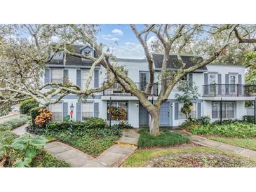 Two-story building with light gray siding, balconies, and landscaping at 4453 Vieux Carre Cir, Tampa, FL 33613