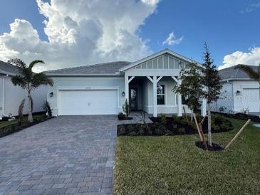 Beautiful new construction home with a two-car garage and a landscaped front yard at 10157 Beachwalk Dr, Englewood, FL 34223