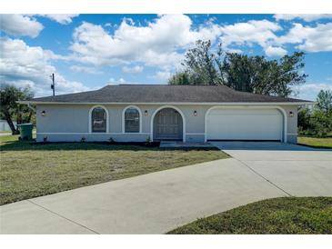 Single story home with attached garage and landscaped lawn at 11339 Gulfstream Blvd, Port Charlotte, FL 33981