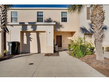 Two-story townhome with attached garage and driveway, surrounded by palm trees at 12935 Shady Fern Ln, Gibsonton, FL 33534