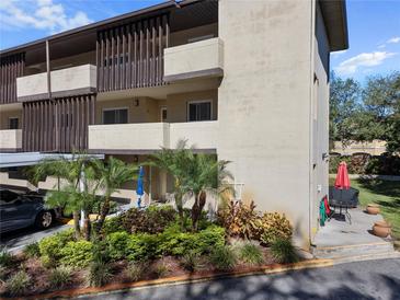 Exterior view of condo building showcasing landscaping and parking at 1247 S Martin Luther King Jr Ave # 107, Clearwater, FL 33756