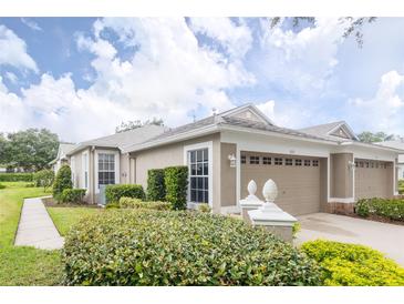 Charming home featuring a well-manicured lawn, neatly trimmed hedges, and an attached two-car garage at 5733 Heronpark Pl, Lithia, FL 33547