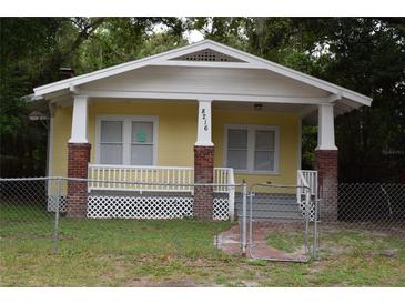 Yellow bungalow with front porch and brick columns at 8216 N 14Th St, Tampa, FL 33604