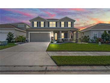 Two-story house with a large front yard, two-car garage, and neutral color scheme at 10507 Daybreak Gln, Parrish, FL 34219
