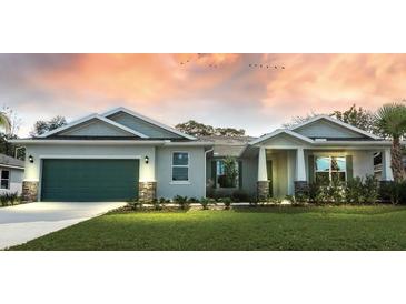 Two-story house with green garage door, stone accents, and landscaped lawn at 142 Fairway Rd, Rotonda West, FL 33947