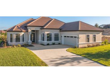 One-story home with tile roof, attached garage, and landscaped lawn at 2451 N Buckmeadow Loop, Hernando, FL 34442