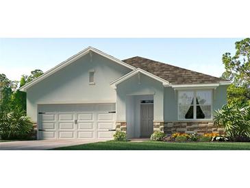 One-story house with light blue exterior, stone accents, and a two-car garage at 3318 Ivy Hollow Dr, Plant City, FL 33565