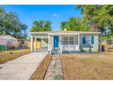 Charming bungalow with a covered porch, updated paint, and a landscaped yard at 7302 N Highland Ave, Tampa, FL 33604