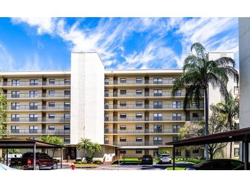 Three-story condo building with parking and lush landscaping at 900 Cove Cay Dr # 2B, Clearwater, FL 33760