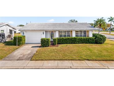 Charming single-story home with a white exterior, attached garage, and landscaped yard at 9201 40Th N Way, Pinellas Park, FL 33782
