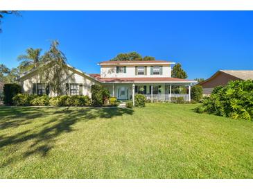 Two-story house with a green lawn, and mature trees in the front yard at 11114 Lake Sassa Dr, Thonotosassa, FL 33592