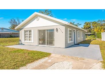 Gray house with a white roof, sliding glass doors, and a concrete patio at 4508 26Th S Ave, Tampa, FL 33619