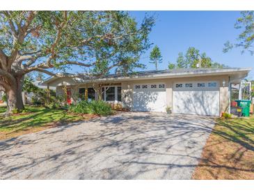 Ranch style home with mature landscaping, two-car garage, and large driveway at 12593 80Th Ave, Seminole, FL 33776