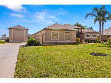 Single-story home with attached garage and lush landscaping at 15435 27Th E Ct, Parrish, FL 34219