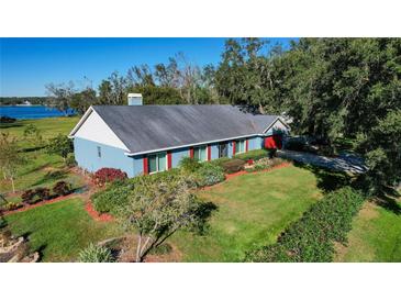 Ranch-style home with blue siding, red shutters, and a spacious lawn at 3111 Lewis Rd, Dover, FL 33527