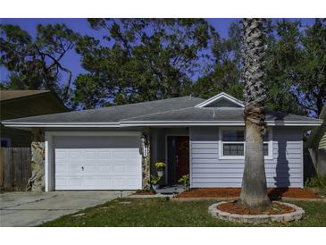 Charming ranch home with gray siding, white garage door, and landscaping at 3159 138Th Pl, Largo, FL 33771