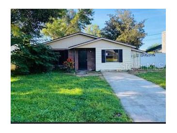 Cute ranch-style home with a grassy lawn and driveway at 502 Calhoun Ave, Seffner, FL 33584