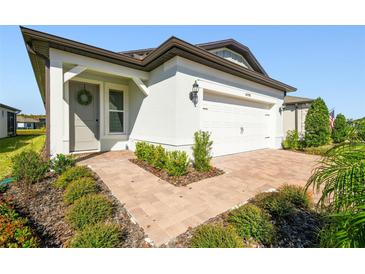 Single-story home with a two-car garage and landscaped front yard at 6098 Shorebird Br, Land O Lakes, FL 34638