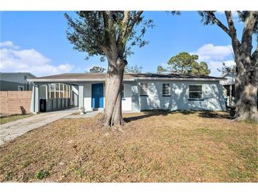 Cute bungalow style home with a blue door and carport at 6342 S Lansdale Cir, Tampa, FL 33616