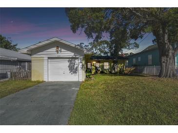 Ranch style home with a carport, well-maintained lawn, and mature trees at 2609 Meadowbrook Dr, Palm Harbor, FL 34684