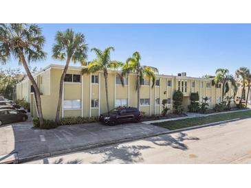 Inviting exterior of a light yellow building with palm trees and ample parking at 3206 W Azeele St # 100, Tampa, FL 33609