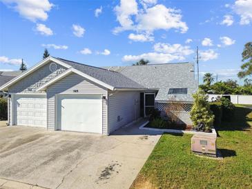 Cute two-bedroom home with a two-car garage and a small, well-manicured lawn at 569 Daventry Sq, Palm Harbor, FL 34683