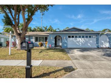 A charming ranch home with a two-car garage and well-manicured lawn at 8408 Monarch Cir, Seminole, FL 33772