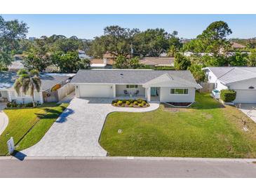 Aerial view of a charming ranch home with a large grassy yard and a paved driveway at 1470 Hill Dr, Largo, FL 33770