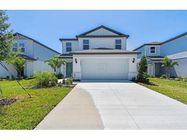 Charming two-story home featuring a well-manicured lawn and a spacious driveway at 10541 Hidden Banks Gln, Parrish, FL 34219
