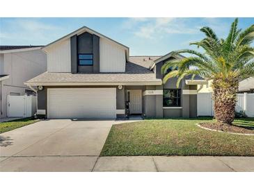 Two-story house with gray siding, white accents, and a two-car garage at 11228 Shadybrook Dr, Tampa, FL 33625