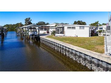 White mobile home on the waterfront with a boat lift at 162 S Saint Thomas Cir, Apollo Beach, FL 33572