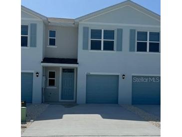 Charming townhouse with blue shutters and attached one-car garage at 4596 Pleasant Ave, Palm Harbor, FL 34683