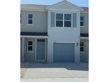 Light blue townhouse features a one-car garage and charming architectural details at 4600 Pleasant Ave, Palm Harbor, FL 34683