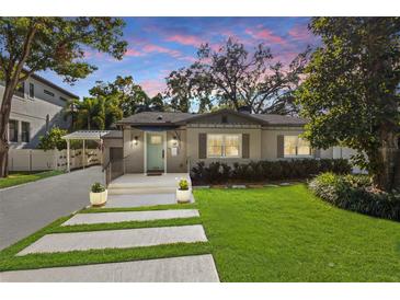 Charming home with a manicured lawn, modern walkway and a covered entry with light blue door at 2934 W Coachman Ave, Tampa, FL 33611