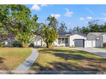 Renovated home with modern facade, gray garage door, and landscaped lawn at 3311 Melton N St, St Petersburg, FL 33704