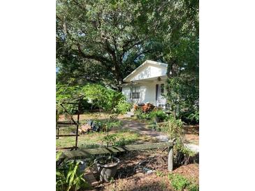 Ranch style home nestled under large shade trees, with a spacious yard at 111 14Th Se St, Ruskin, FL 33570