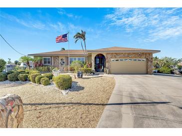 Single-story home with landscaped yard, attached garage, and American flag at 925 Golf Island Dr, Apollo Beach, FL 33572