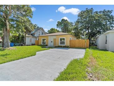 Newly constructed light yellow home with a wooden fence and spacious driveway at 1432 19Th S St, St Petersburg, FL 33712