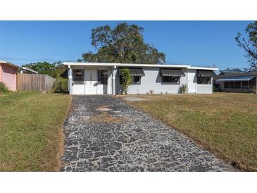Ranch style home with gray exterior, driveway, and landscaped lawn at 10273 109Th Ave, Largo, FL 33773